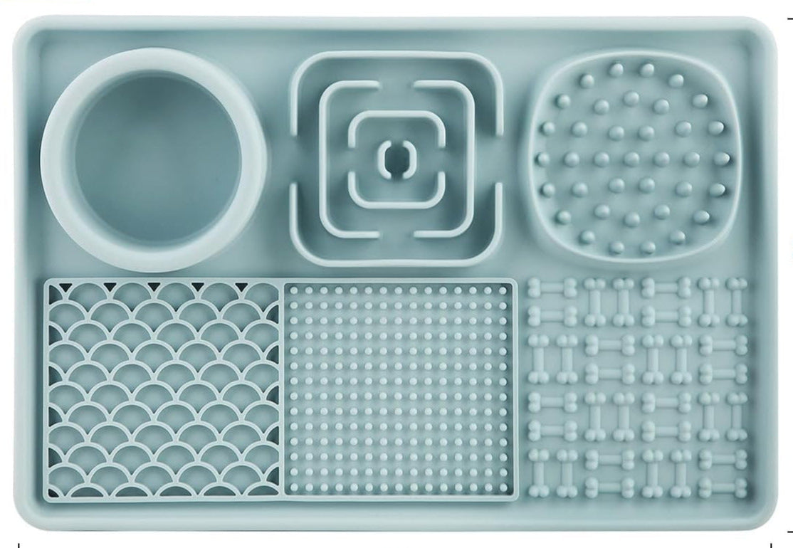 Tørfoder og vådfoder er spredt ud over de forskellige sektioner på slikkemåtten, hvilket illustrerer dens alsidighed.