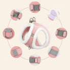 Detaljeret nærbillede af lyserødt plysforet katteharnes, der viser plastikspænder, metal D-ringe til snor, justerbare stropper og indbyggede refleksdetaljer.