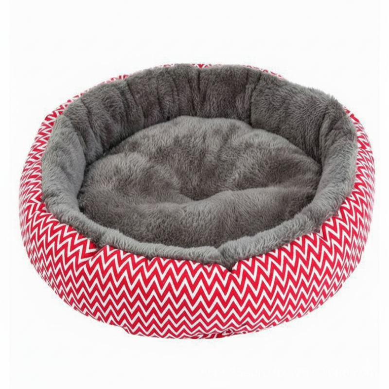 En tom, rund kæledyrsseng i rødt og hvidt zigzag-mønster med et blødt gråt plysfór. Perfekt til katte og små hunde, fotograferet mod en hvid baggrund. 
