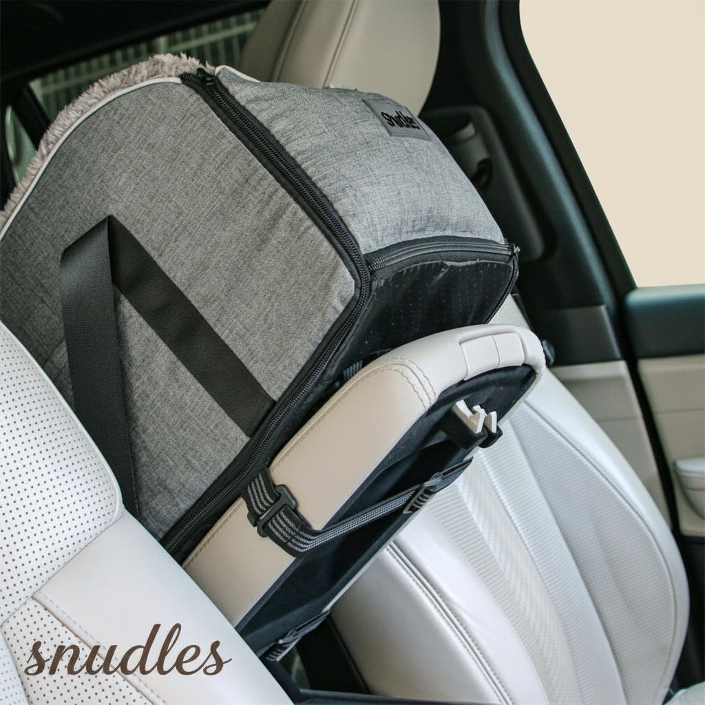 Detaljeret billede af et gråt Snudles hunde bilsæde, der er fastgjort stabilt og nemt til ryglænet af et beige bilsæde, hvilket sikrer stabilitet og sikkerhed under rejsen.