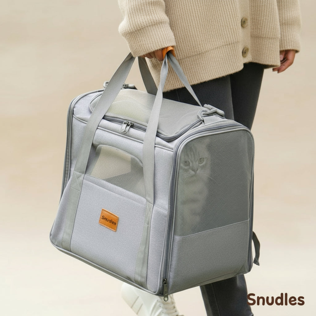 Grå, åben Snudles kattebærepose med udtagelig, blød katteseng. Perfekt åndbar bærepose til rejse eller transport. Katten sidder komfortabelt indeni.