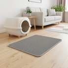 En stilfuld grå dobbeltlags kattegrusmåtte placeret foran en kattebakke, som effektivt fanger kattegrus og holder dit hjem rent og fri for spredt kattegrus. Den smarte design med to lag sikrer maksimal opsamling og nem tømning.