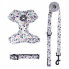 Komplet Snudles hundesæt i lyse farver med tegneserie dinosaur og UFO mønster: Hundesele, matchende halsbånd og hundesnor.